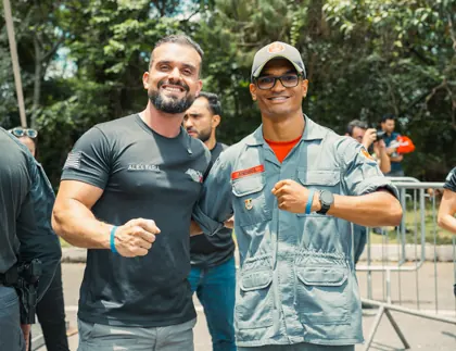 Aluno aprovado abraçando o instrutor Alex Faria